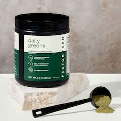 Daily Greens jar with scoop and greens powder