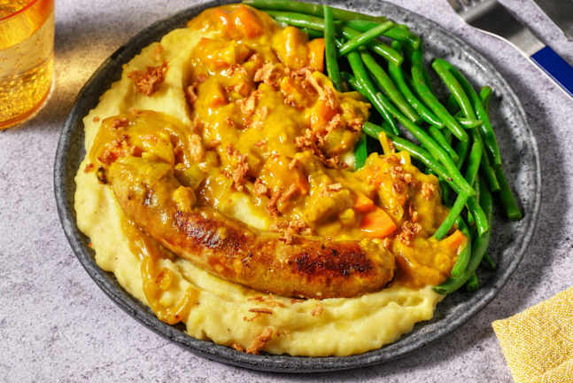 Saucisse de porc en sauce au curry et oignons frits