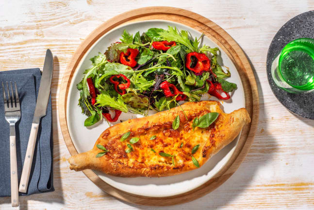 Margherita Pizzaschiff mit grünem Salat und gerillter Paprika