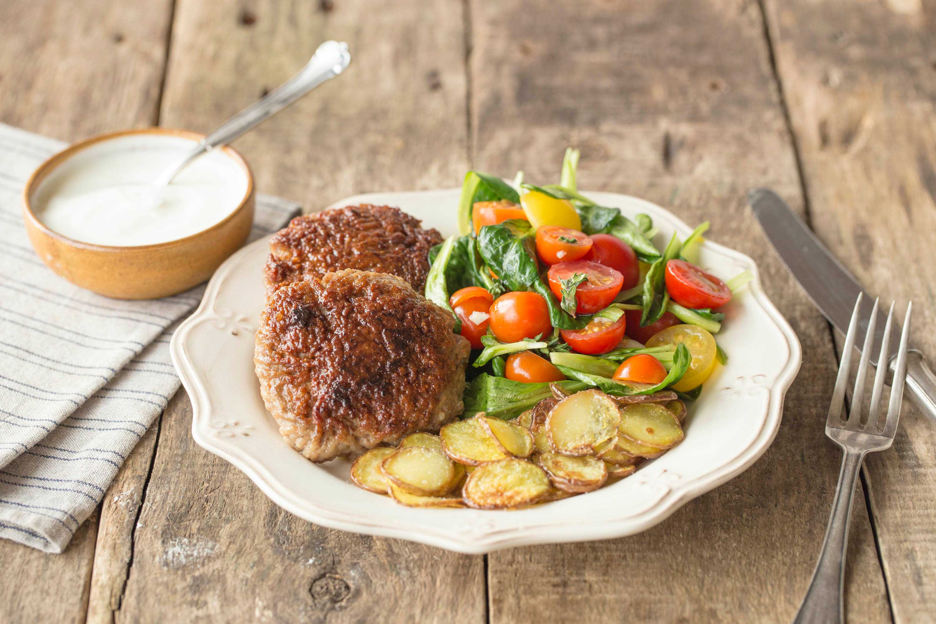 Hamburgertjes met gebakken rosevalaardappelen en tomatensalade