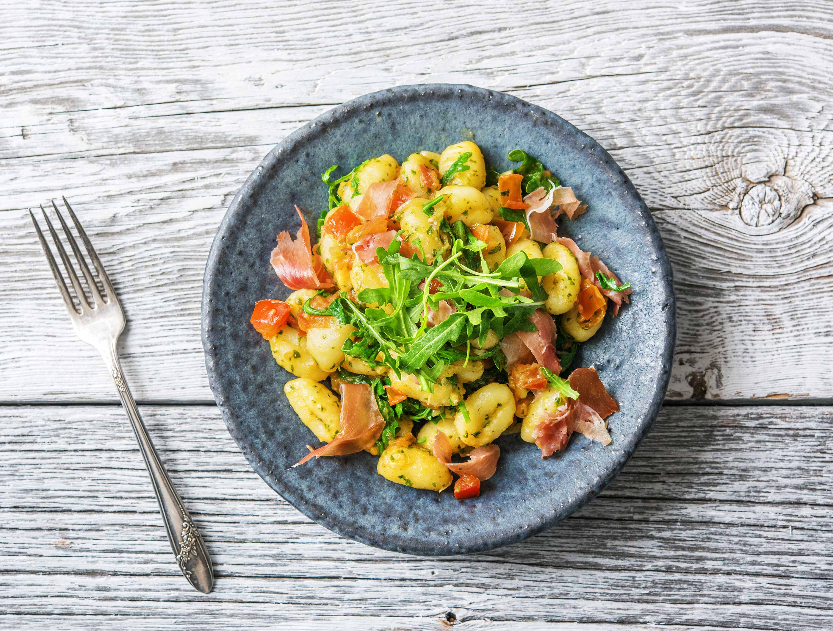 Gnocchi met serranoham, groene pesto en rucola
