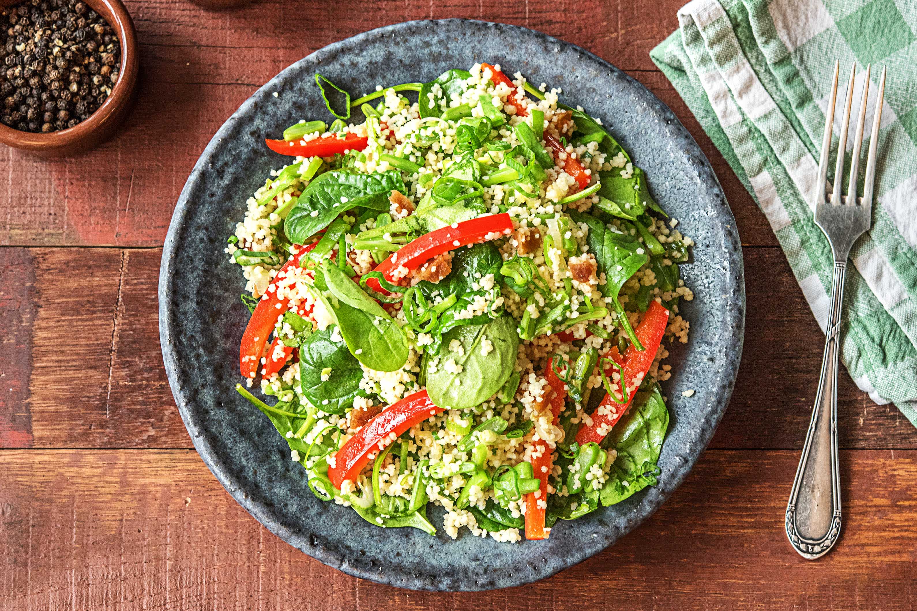 Couscous met abrikozen, spinazie en gebakken groenten in honing-citroendressing