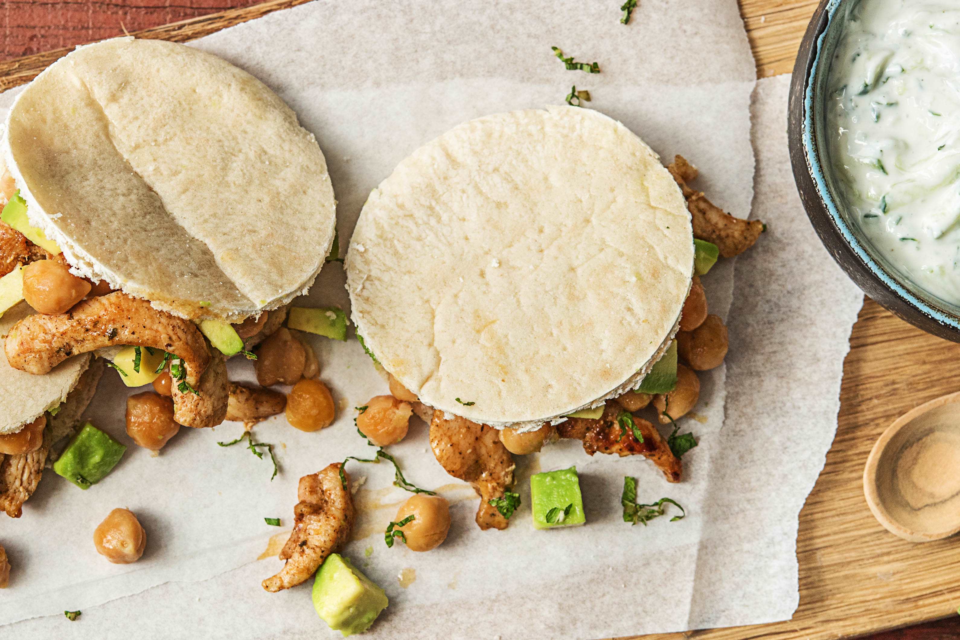 Kipgyros met avocado-kikkererwtensalade, komkommer-knoflooksaus en knapperige pitabroodjes
