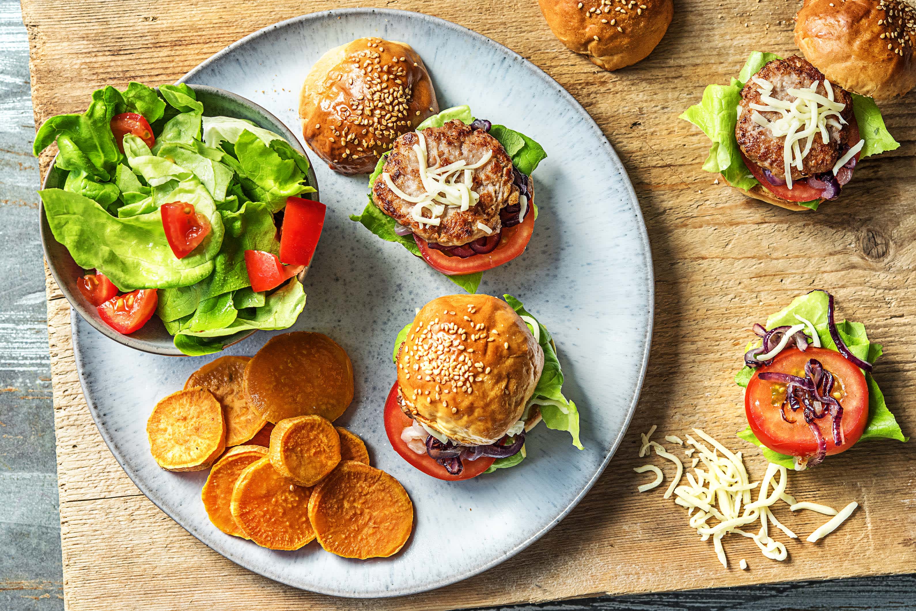 Kip-cheeseburgers met zoete rode ui, geroosterde bataat en frisse salade