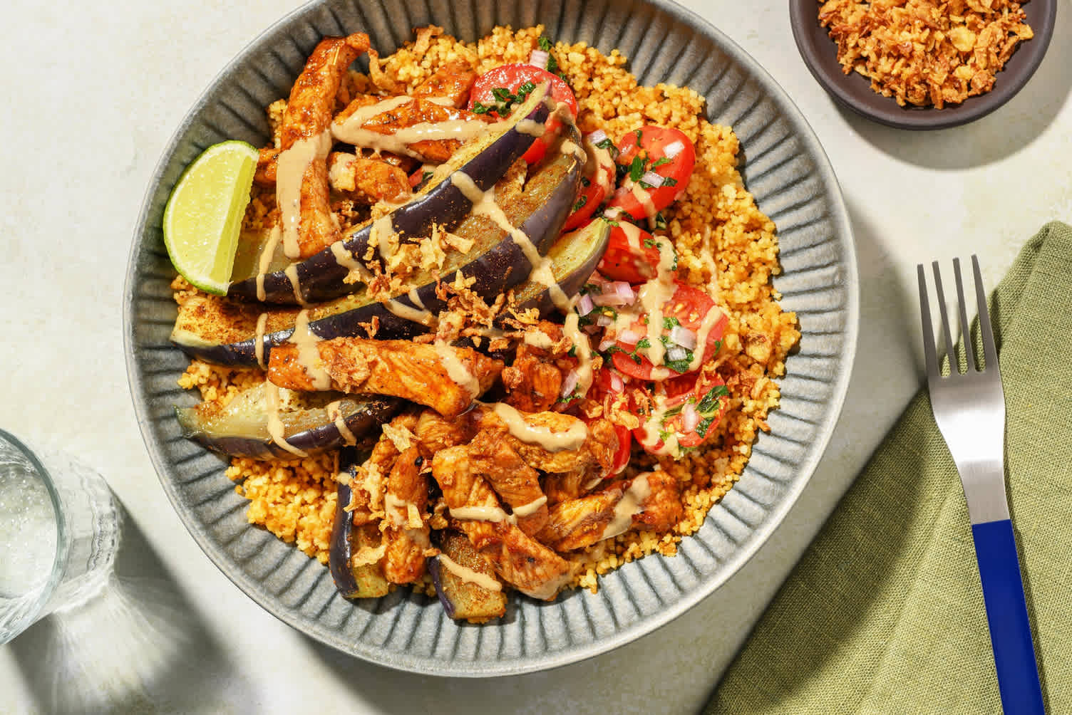 Bowl de semoule complète au porc & aubergine, sauce au tahini