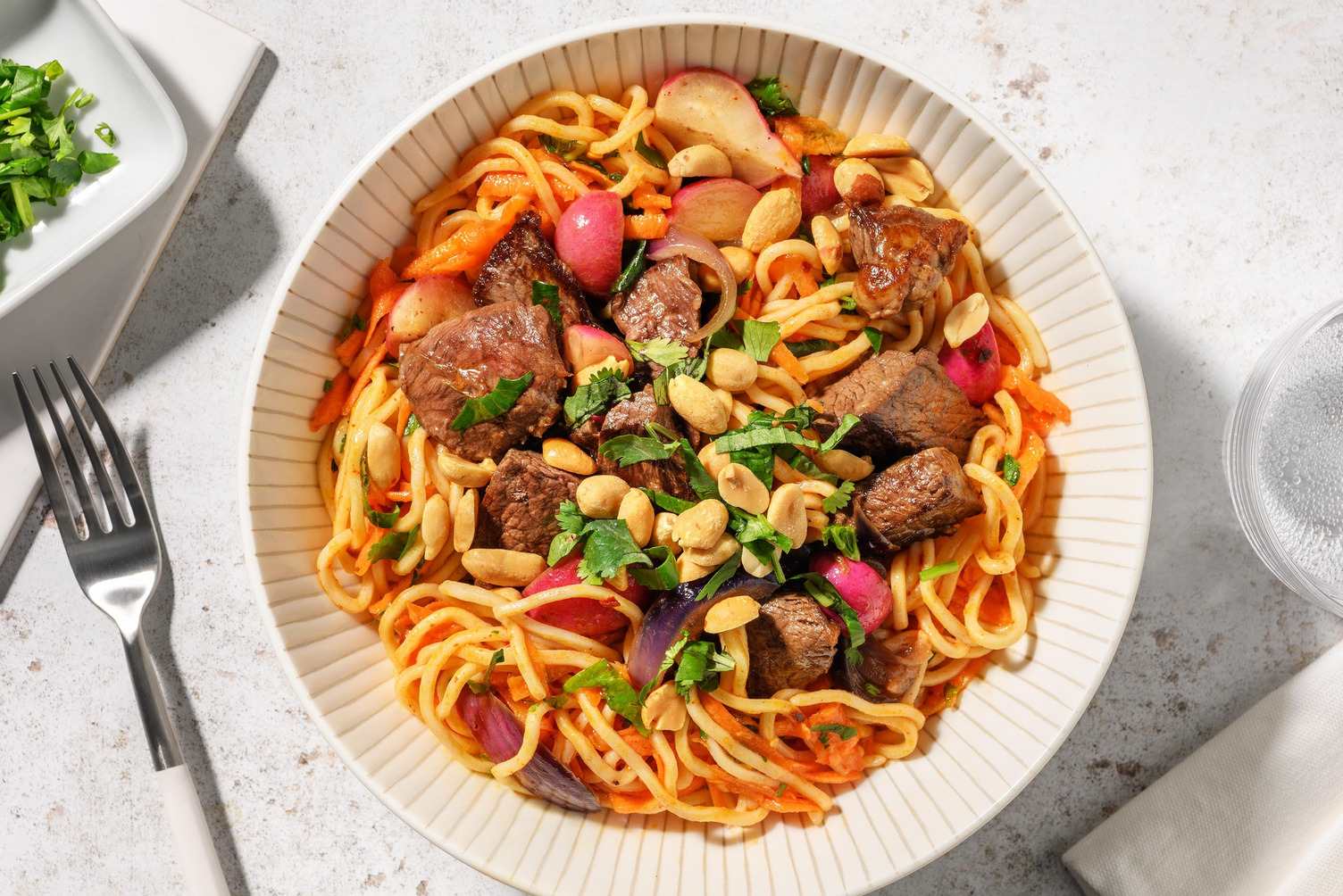 Salade de nouilles aux émincés de steak, herbes fraîches et cacahuètes