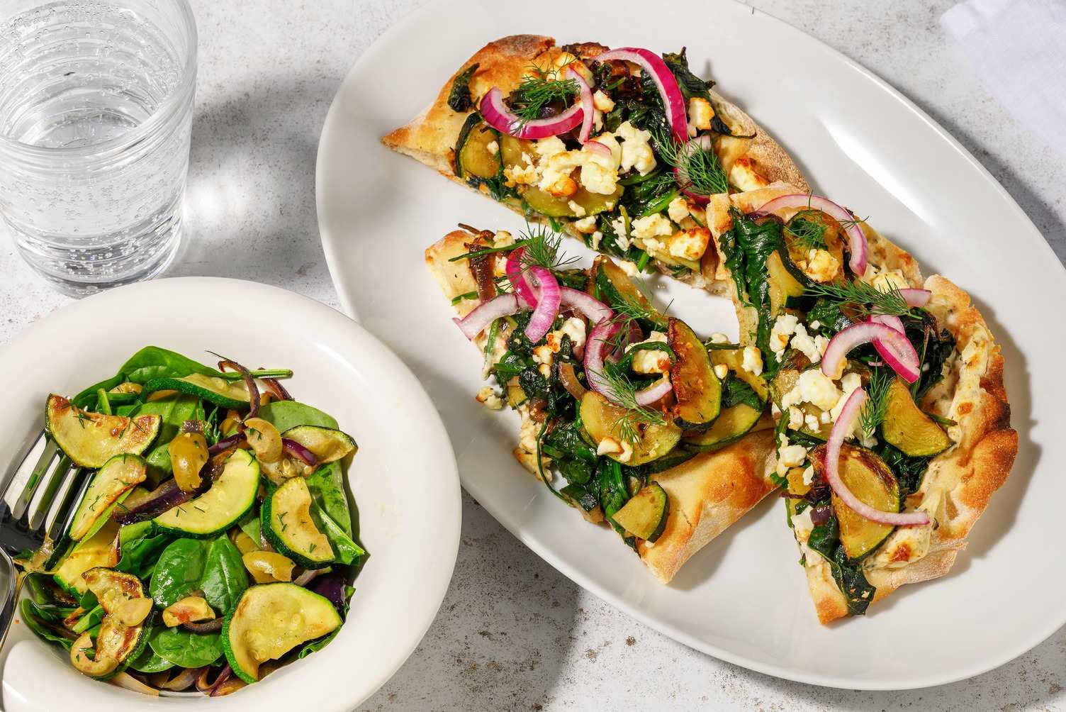 Pizza sur naan aux légumes, fromage à la grecque et olives