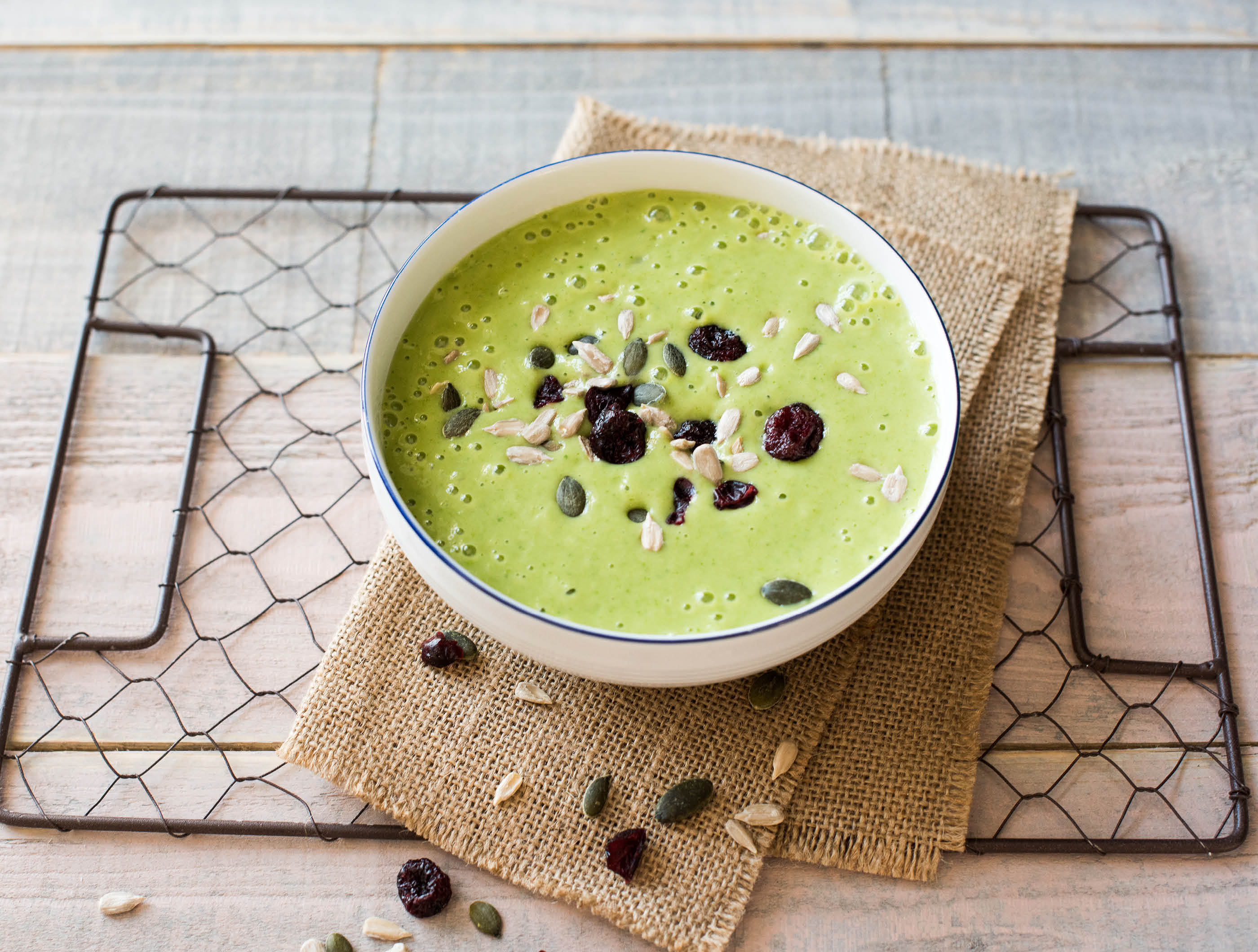 Smoothie bowl à l'ananas et aux épinards avec mélange de canneberges et de graines