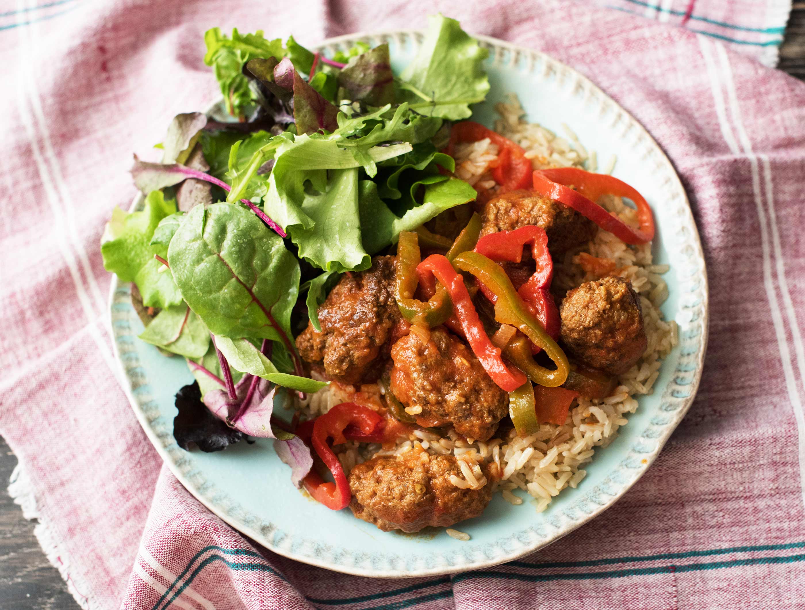 Kruidige köfte in zoetpittige saus met rijst en frisse salade