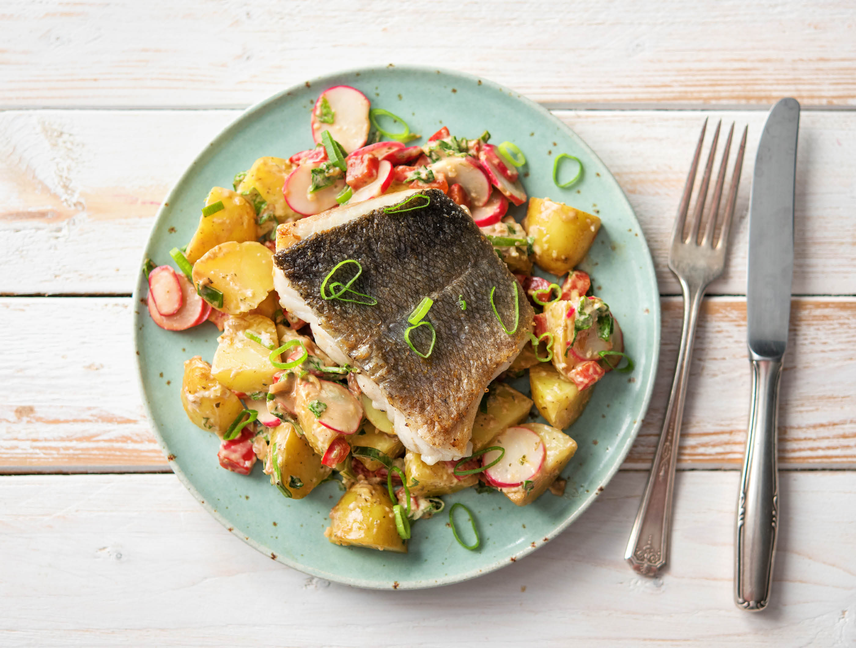 Op de huid gebakken heekfilet met kleurrijke aardappelsalade