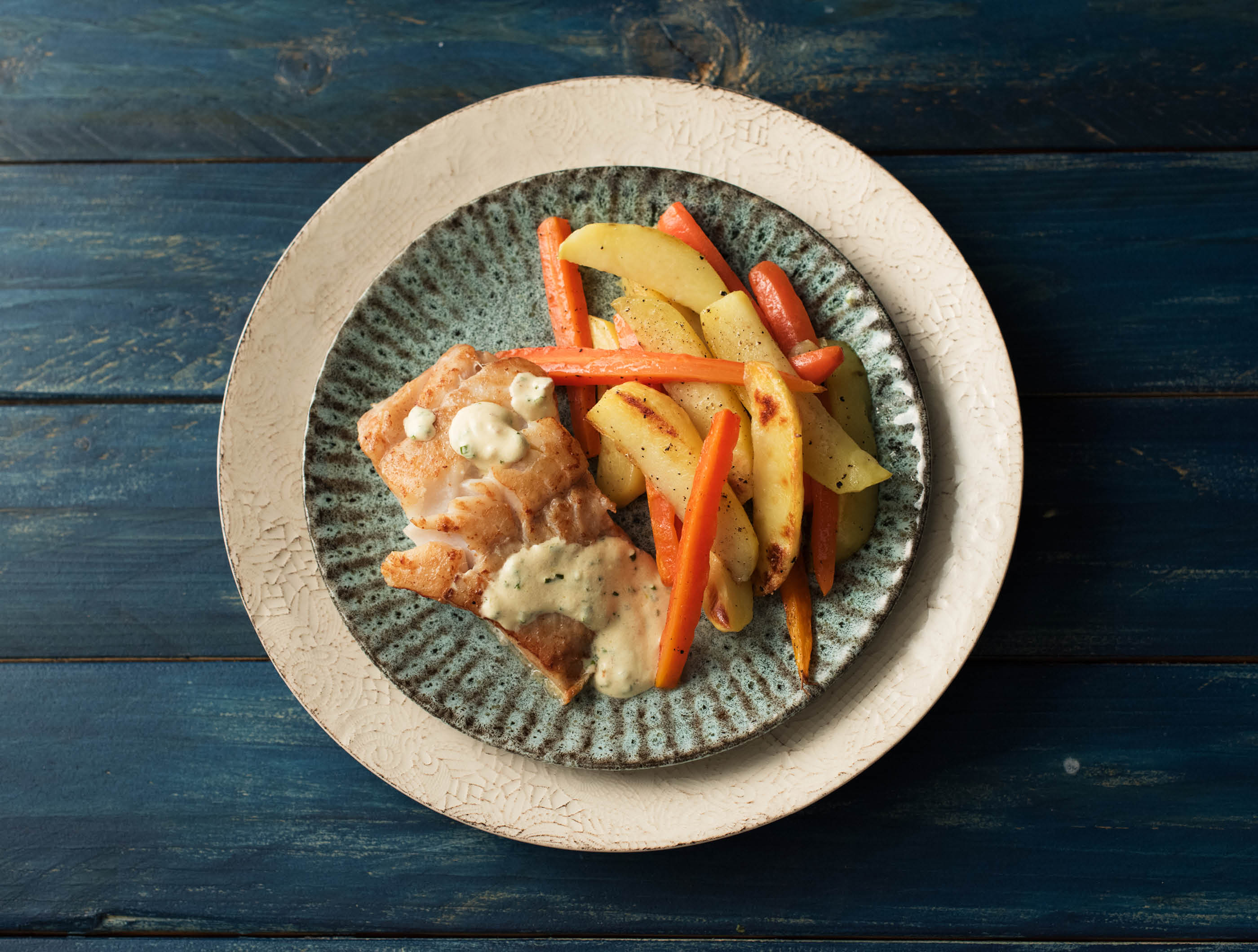 Schelvis met bieslooksaus en geroosterde bospeen en aardappelen