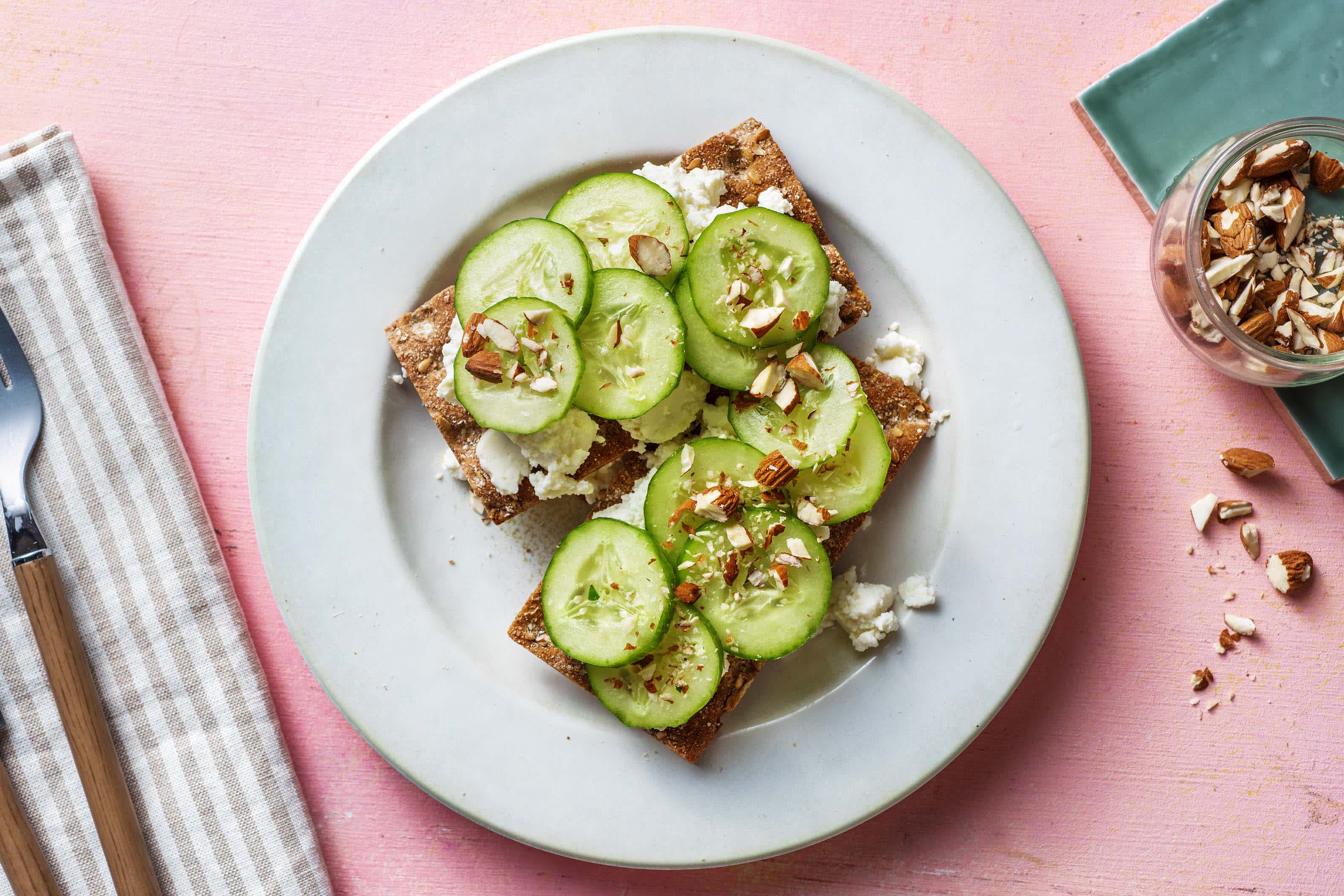 Crackers met ricotta, komkommer en gezouten amandelen