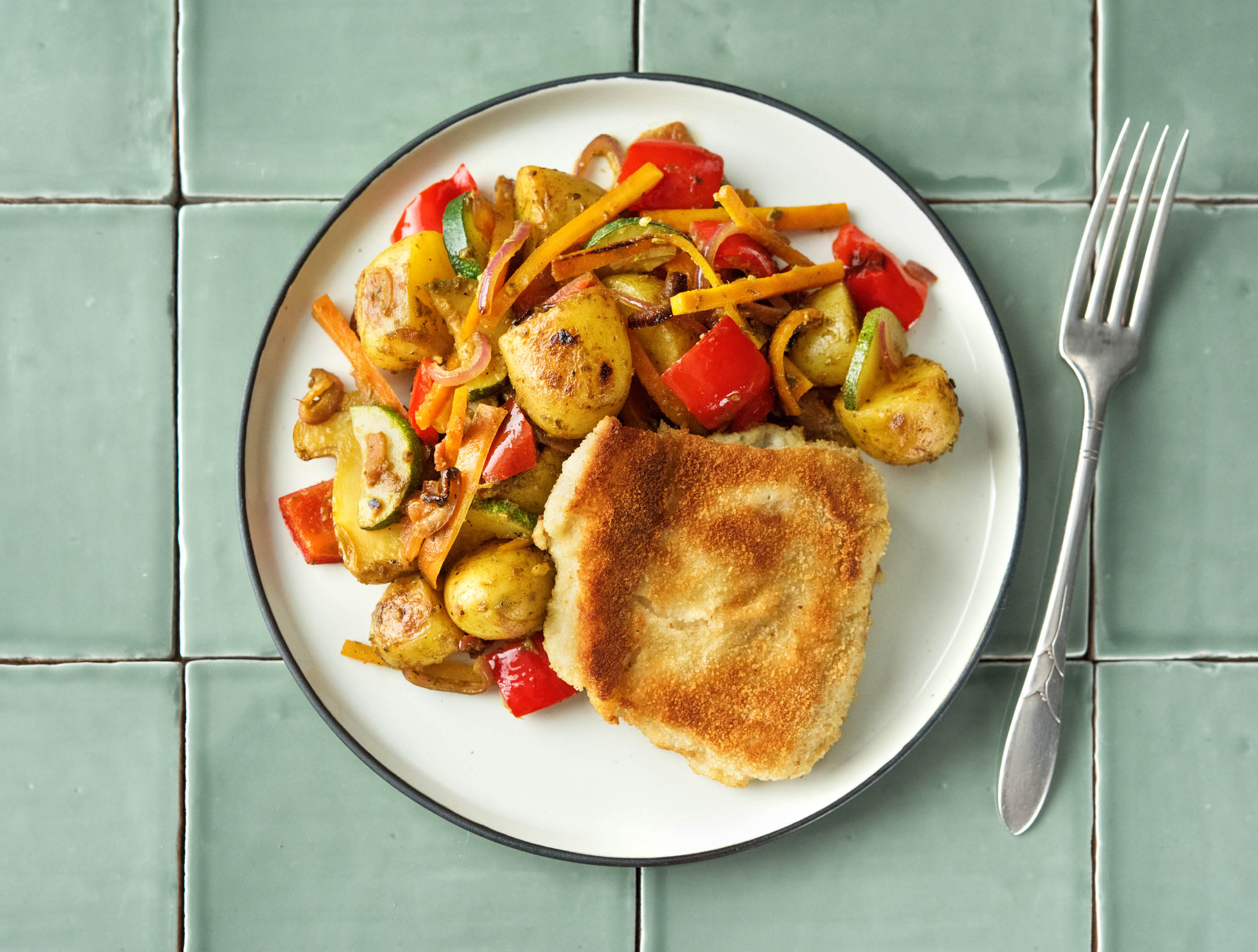 Escalope de poisson panée aux légumes, pesto et grenailles