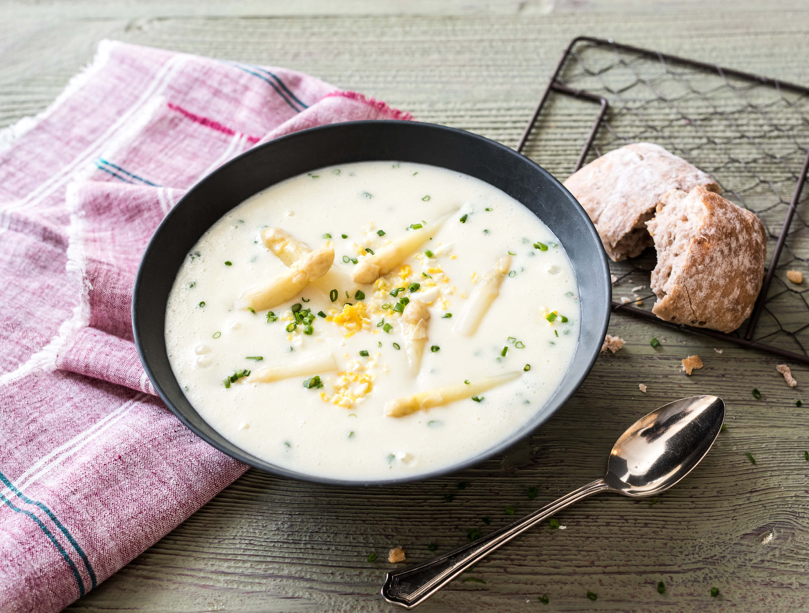 Witte aspergesoep met ei, bieslook en volkoren rozijnenbroodje