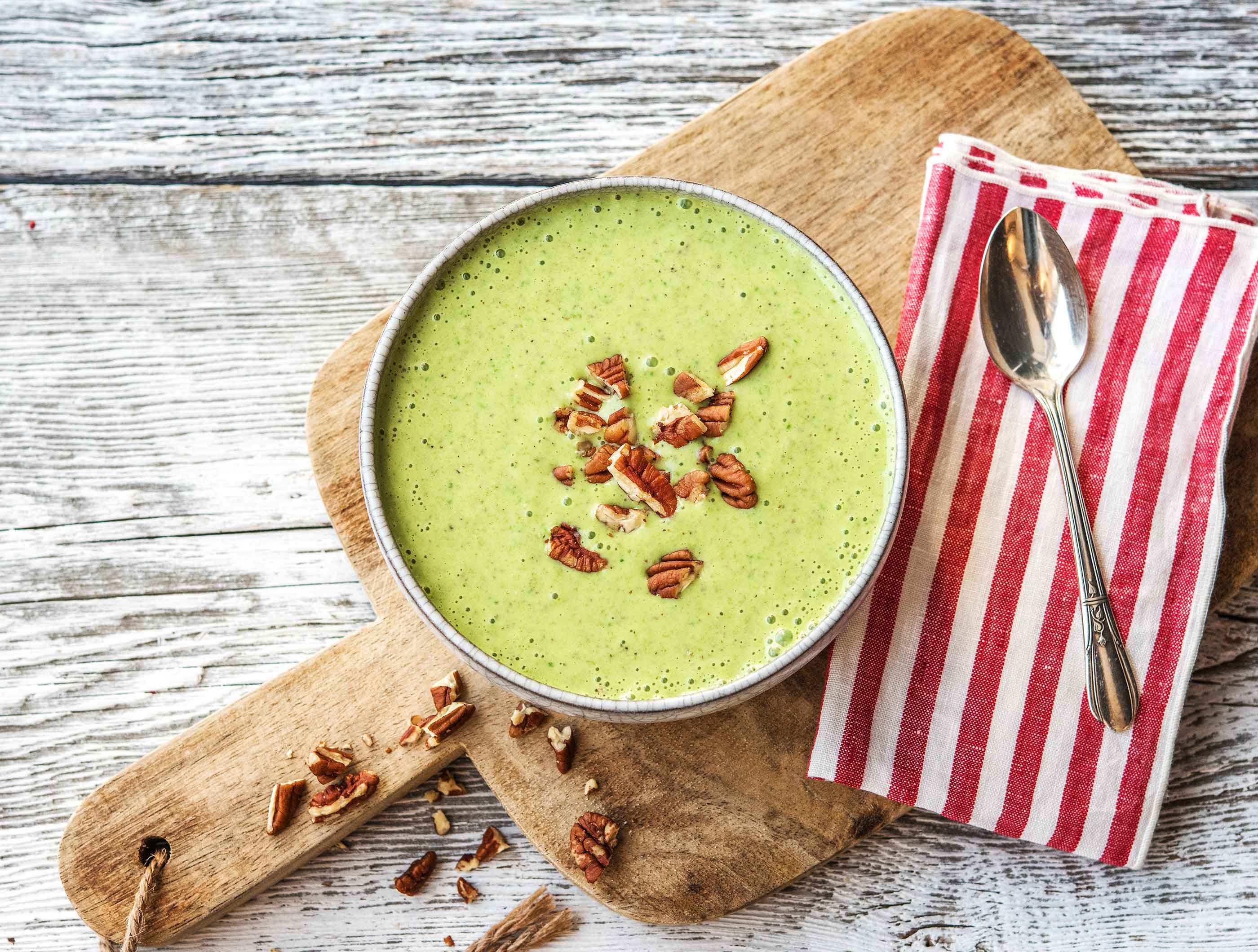 Zoete, groene smoothiebowl met knapperige pecannoten