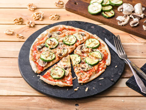 Platbroodpizza met gegrilde courgette, paddenstoelen en belegen kaas
