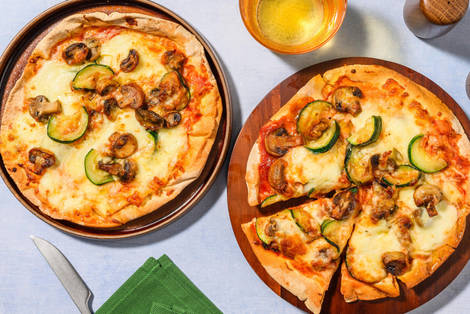 Pizza sur pain plat garnie de champignons et courgette