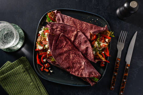 Pains plats garnis de poulet, chorizo, feta et zhoug