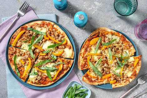 Pizza met gehakt, mozzarella en basilicum