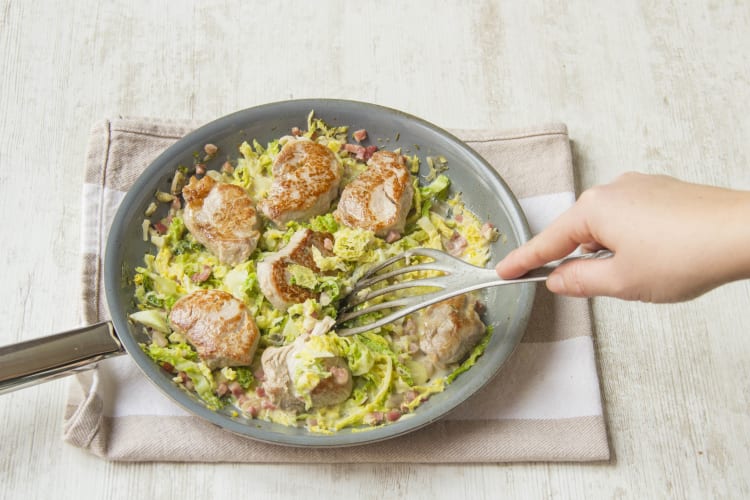 Das Schweinefilet zu der Wirsingpfanne geben.