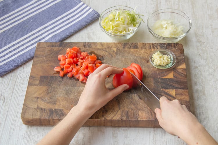 Snijd de prei in fijne ringen en de tomaat klein