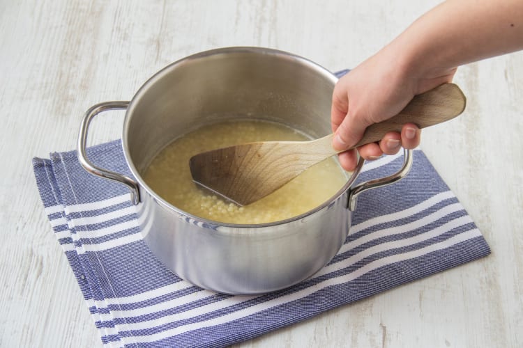 Meng ondertussen de parelcouscous met de bouillon in een pan