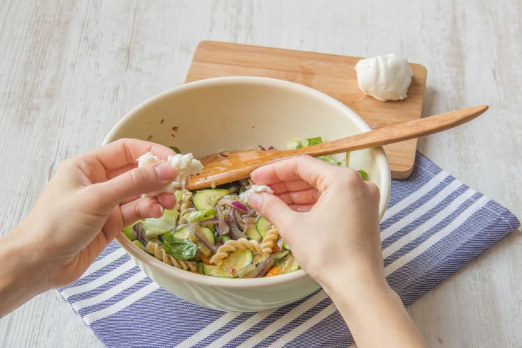 Scheur de buffelmozzarella klein en schep deze door de salade