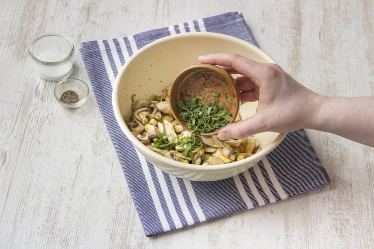 Die Champignons mit den Kräutern und Gewürzen vermengen