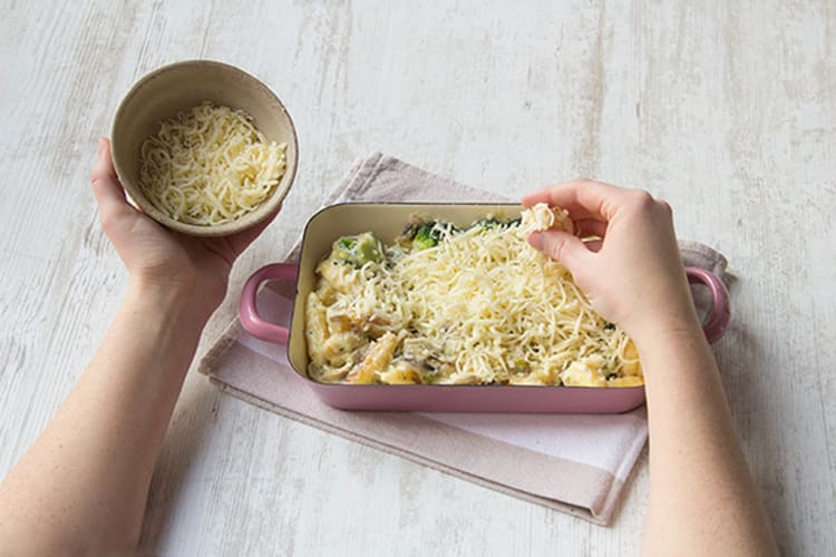 Schnupfnudeln und Gemüse mit Käse bestreuen und backen