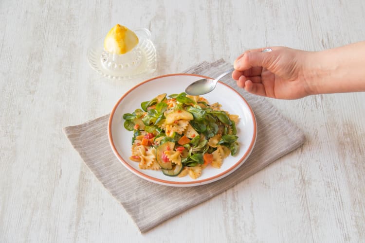 Besprenkel de pastasalade met extra vierge olijfolie en citroensap