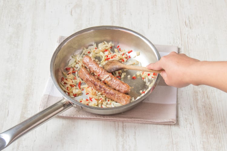 Voeg de ui, knoflook en rode peper bij de kipworst