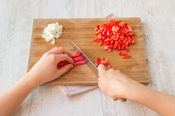Snipper de ui en snijd de puntpaprika klein.