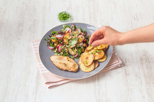 Verdeel de kipfilet, aardappelen en salade over de borden. Garneer de aardappelen met de overige bieslook.