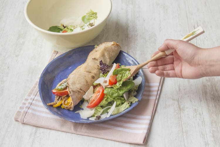 Serveer het platbrood met de salade