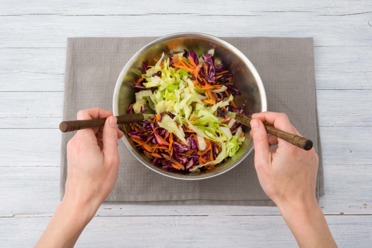 Meng de salade met de dressing.