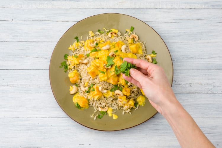 Garneer met cashewnoten en koriander.