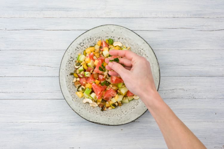 Voeg de munt en noten toe aan de saladekom.