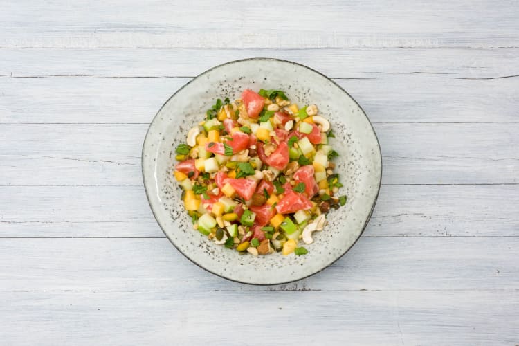 Verdeel de fruitsalade over de kommen.