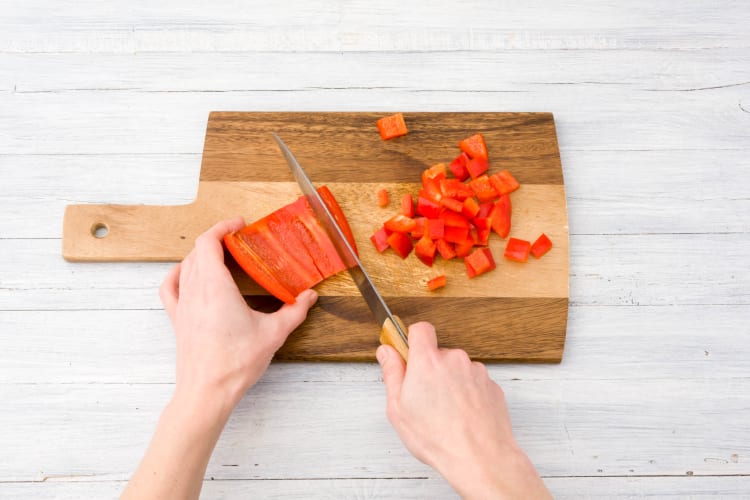 Snijd de rode paprika in blokjes.