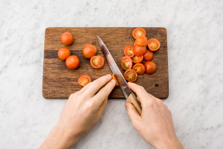 Snijd de cherrytomaten doormidden.