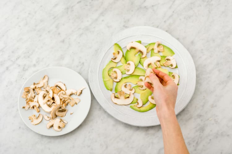 Avocado- und Championscheiben auf Teller verteilen