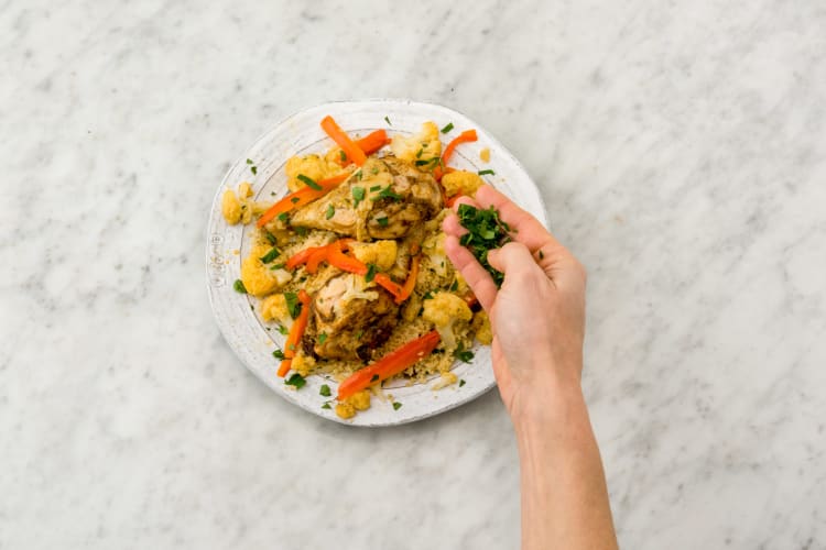 Verdeel de kip en couscous over de borden en garneer met de overige peterselie.