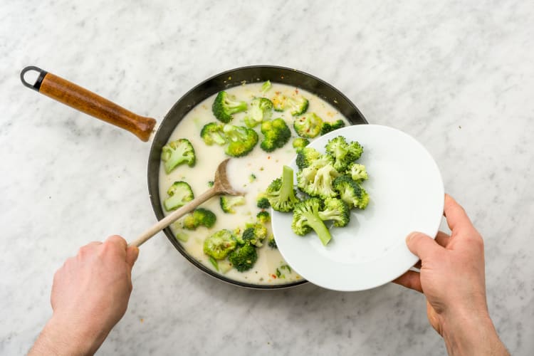 Voeg de bouillon, kokosmelk, broccoli en snijbonen toe.