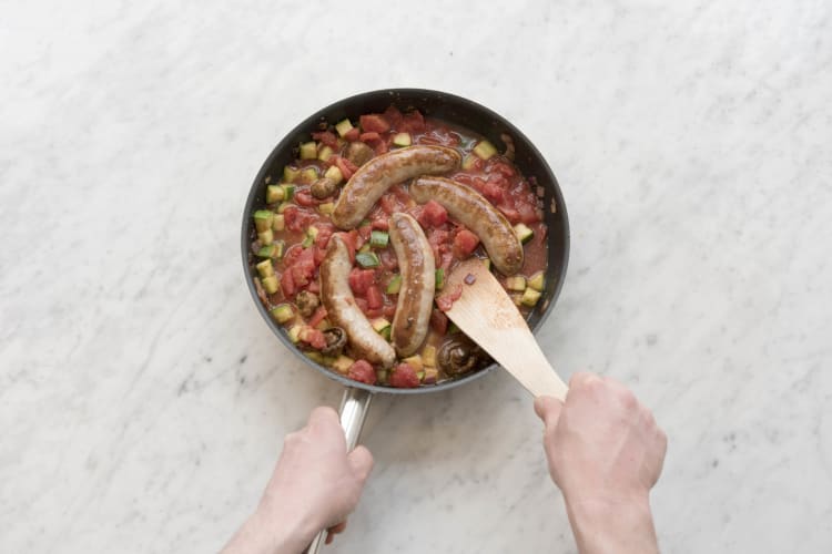 Voeg de runderworstjes terug toe en laat koken.