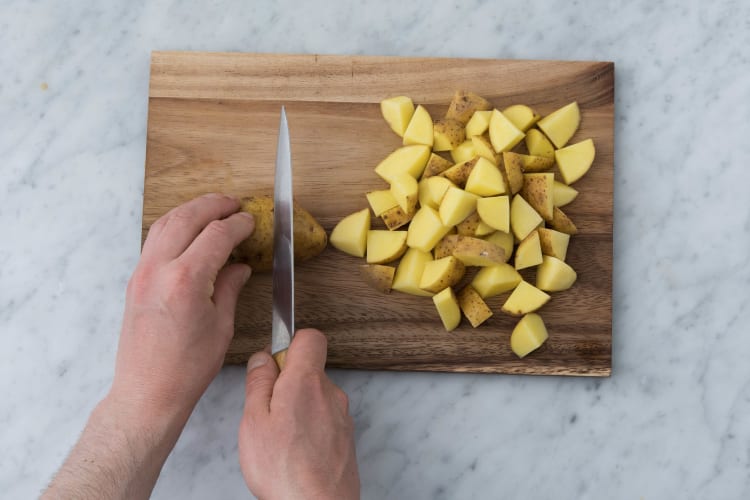 Snijd de aardappelen in kwarten.