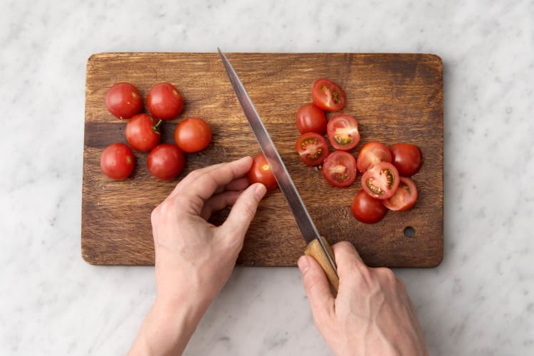 Snijd de cherrytomaten doormidden.