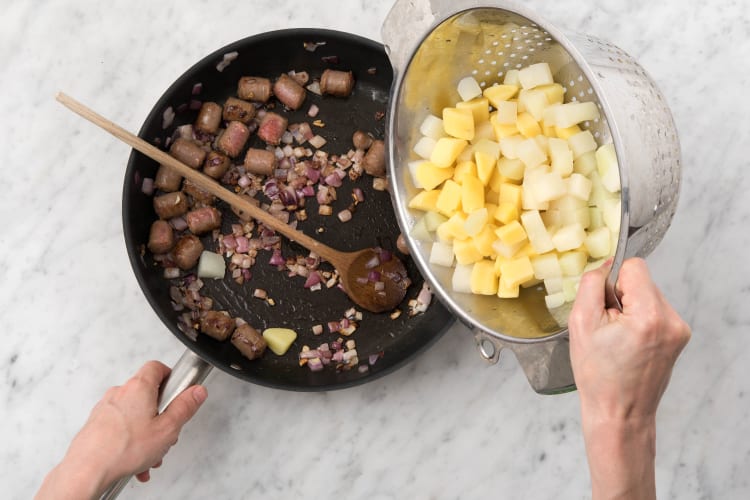 Voeg de aardappel en koolrabi toe aan de pan.