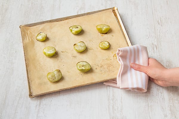 Toss the tomatillos on one side of a parchment-lined baking sheet