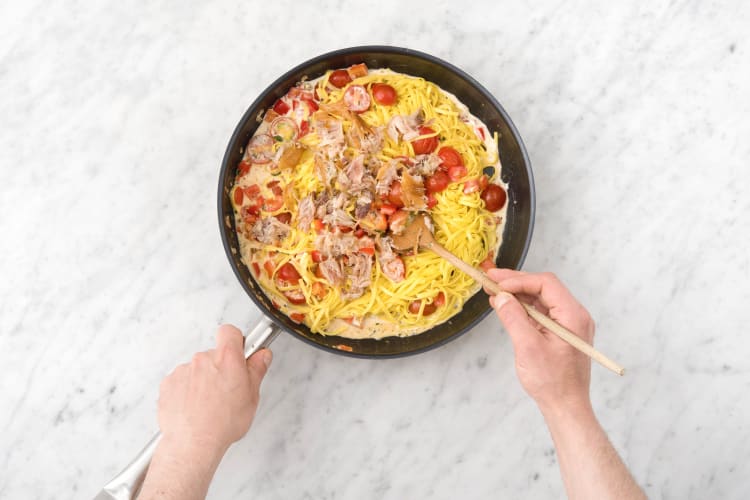 Roer de fettuccine door de saus.