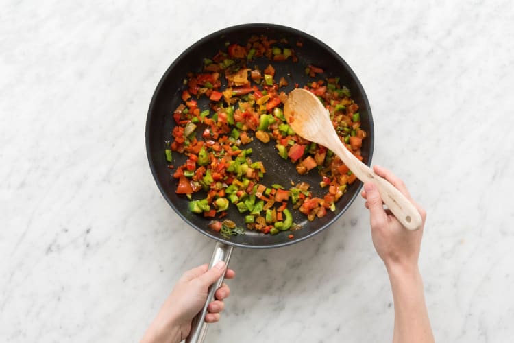 Paprika-, Tomatenwürfel, Majoranblätter und Aprikosenstücke anbraten